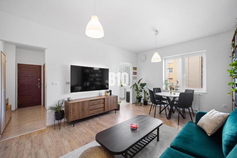 Helles Wohnzimmer einer Zweizimmerwohnung mit Holzboden und Esstisch.