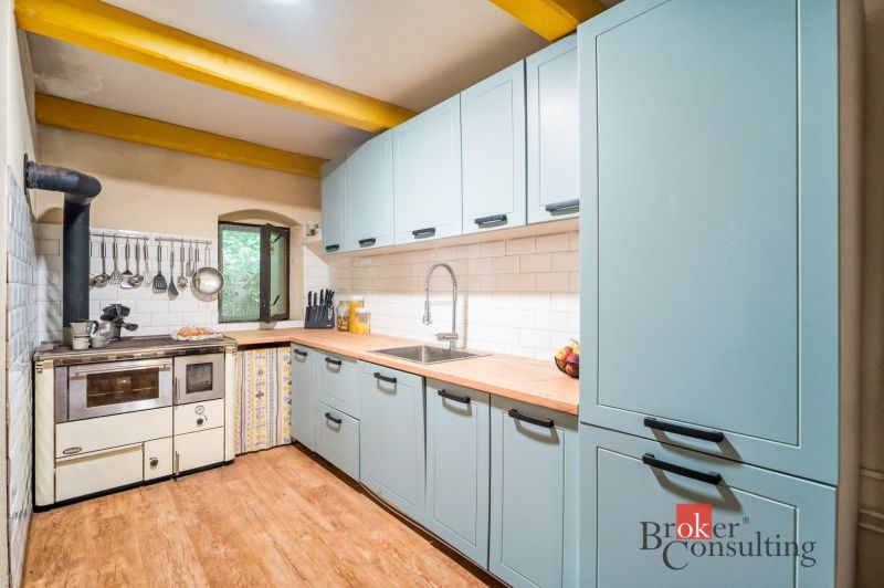 Rustikale Küche in einer Hütte mit Holzboden und traditionellem Ofen.