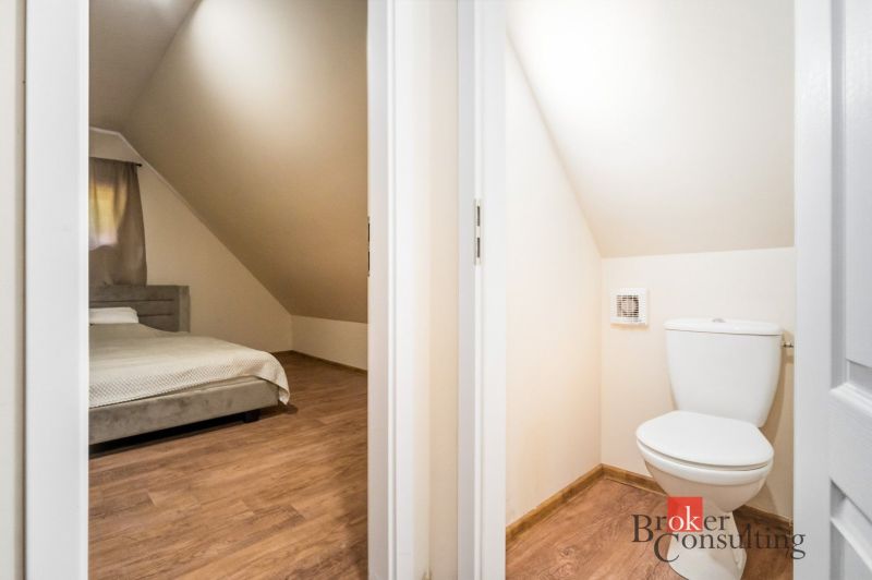 Schlafzimmer und Toilette in einer Hütte mit einem Boden in Holzoptik.