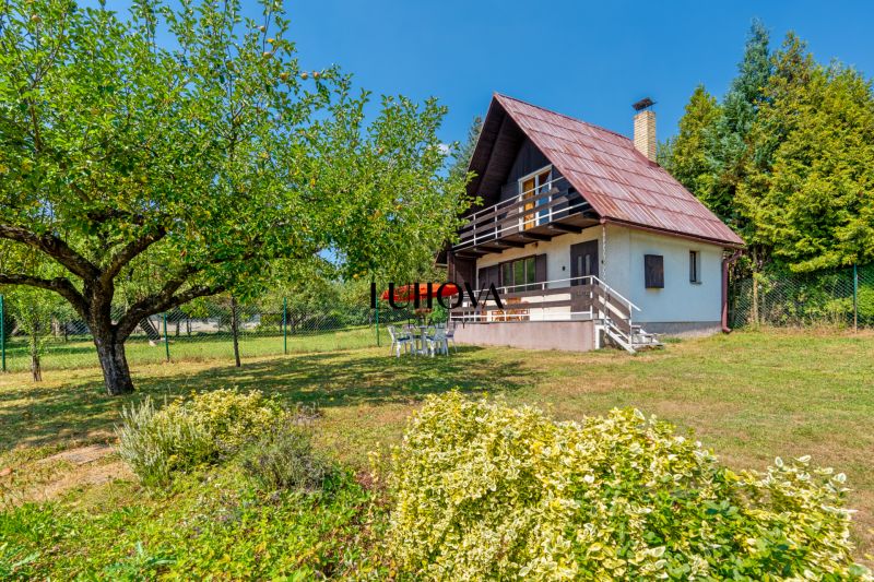 Eine Hütte in Lazy pod Makytou auf Dubková mit Obstbäumen und einem Garten.