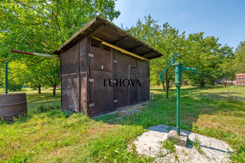 Ein hölzerner Pavillon und eine Handpumpe im Garten bei der Hütte in Lazy pod Makytou, Dubková.