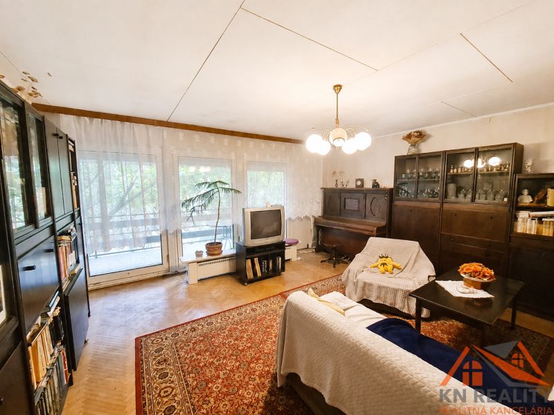 Wohnzimmer in einem Einfamilienhaus mit Teppichboden, Möbeln und Fernseher.