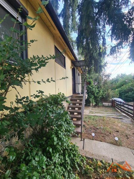 Ein Einfamilienhaus in Svodín, mit einem Vorgarten und einer Treppe zum Haupteingang.