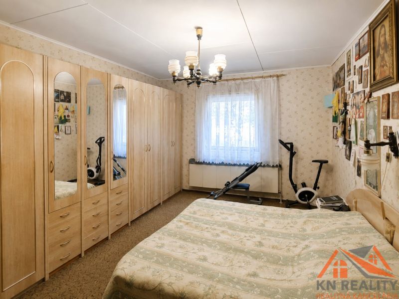 Schlafzimmer in einem Einfamilienhaus mit großem Schrank, Bett und Fitnessgeräten.