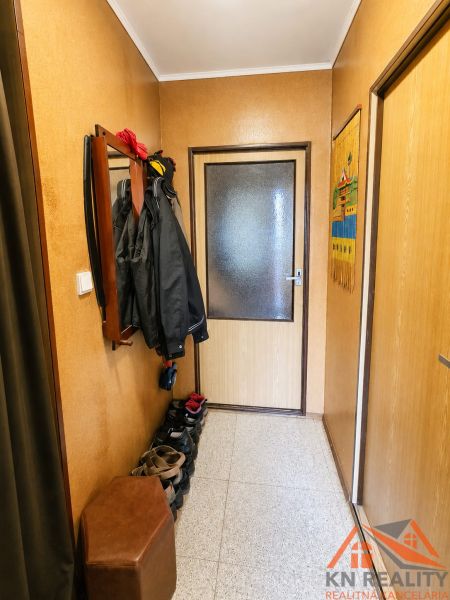 Flur in einem Einfamilienhaus mit Kleiderständer und Schuhschrank, neutrale Farbtöne.