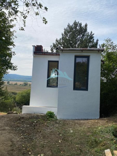 Ein kleines Häuschen in Šahy, umgeben von Bäumen und schöner Natur.