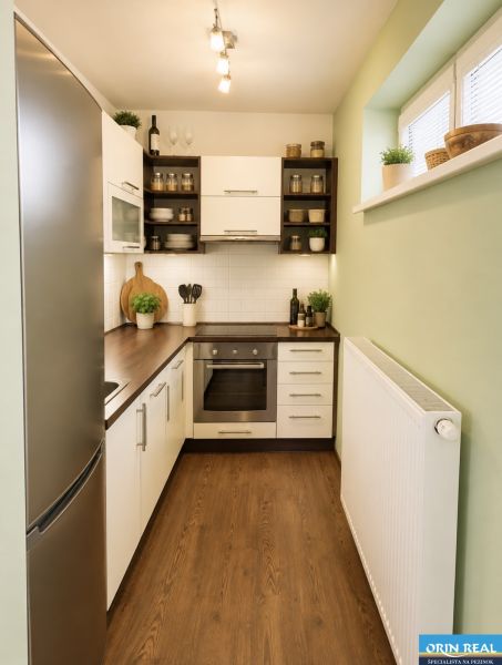 Küche in einer Einzimmerwohnung mit Holzboden und eingebauten Geräten.