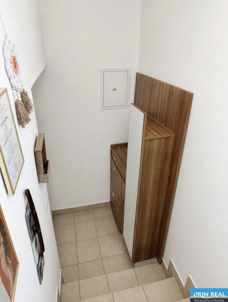 Treppe mit Stauraum in einer Einzimmerwohnung, weiße Wand, Holzdekor.
