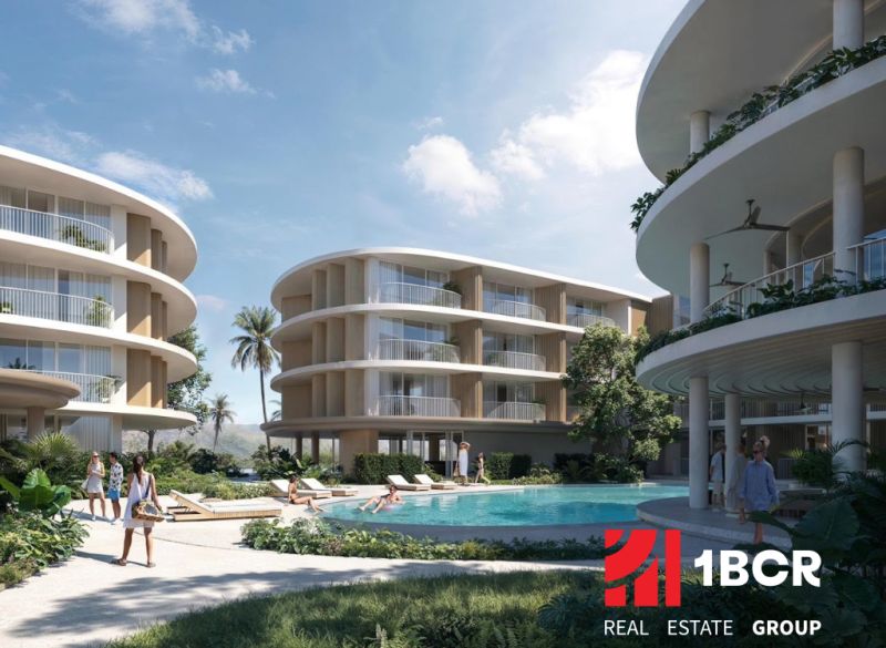 Wohnungsbau in Surat Thani mit abgerundeten Gebäuden und einem Pool in der Mitte des Komplexes.