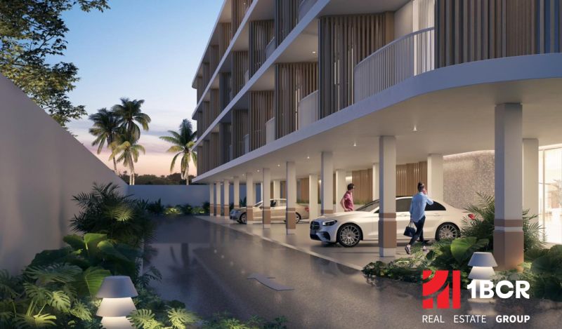Wohnungsbau in Surat Thani: Parken unter einem modernen Gebäude, umgeben von tropischem Grün.