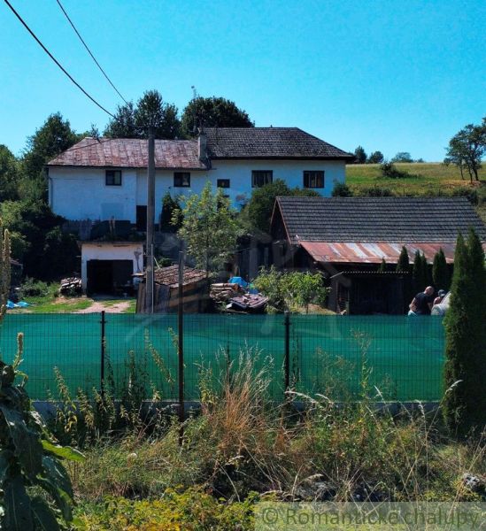 Ein Einfamilienhaus in Stará Turá mit Garten, Umzäunung und Anbauten, mit Blick auf die Landschaft.