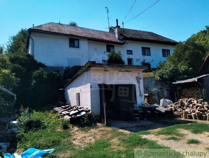 Ein Einfamilienhaus in Stará Turá mit Garage und geschnittenem Holz im Hof.