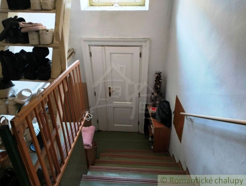Treppe mit Schuhregal und weißen Türen in einem Einfamilienhaus.