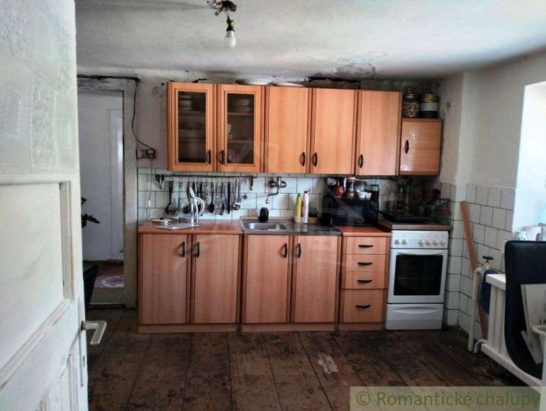 Eine Küche in einem Einfamilienhaus mit einem Boden in Holzoptik und Holzschränken.
