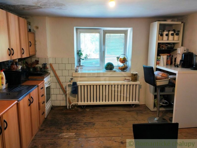 Küche in einem Einfamilienhaus mit Holzboden, ausgestattet mit Geräten und Möbeln.