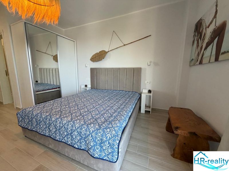 Einzimmerwohnung mit einem bequemen Bett, einem Einbauschrank und einem dekorativen Element an der Wand.