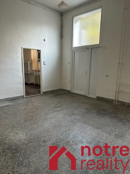 Innenraum eines Büros mit weißen Wänden und einem Boden in Betonoptik.
