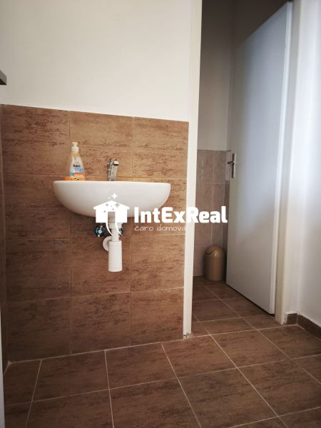 Waschbecken mit Fliesendekor in Geschäftsräumen mit Holzbodendekor.