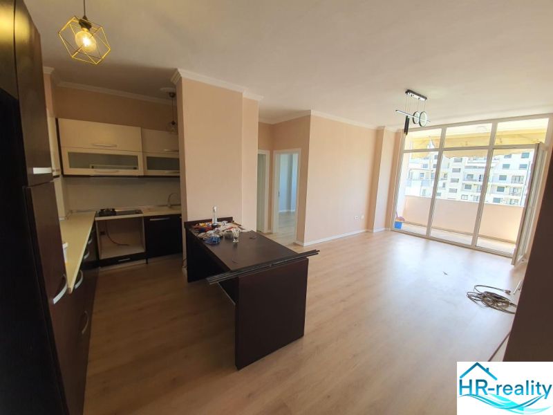 Küche und Wohnzimmer im Ferienapartment, Boden mit Holzdekor, Balkon.