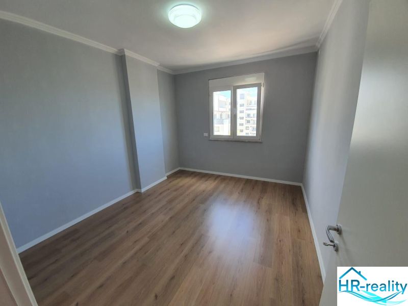 Ein Zimmer in einer Ferienwohnung mit Holzboden und einem Fenster.
