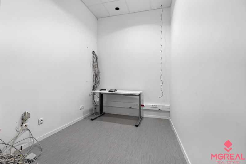 Büroraum mit einfachem Tisch, Kabeln und Steckdosen an der Wand, Geschäftsräume.