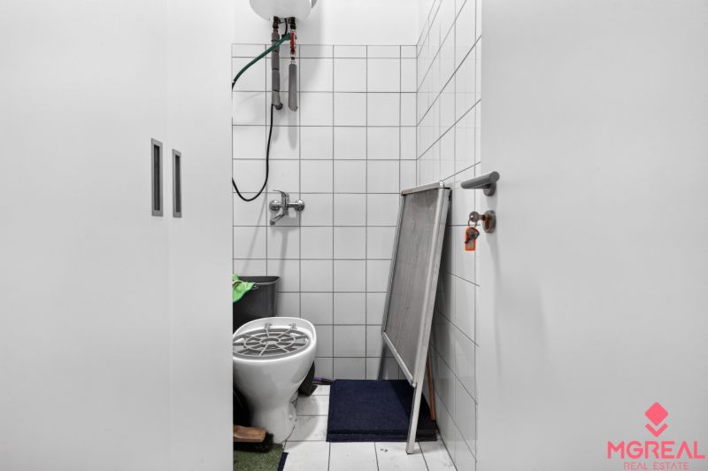 Kleine Räumlichkeit in Geschäftsräumen, mit Toilette und Stauraum.
