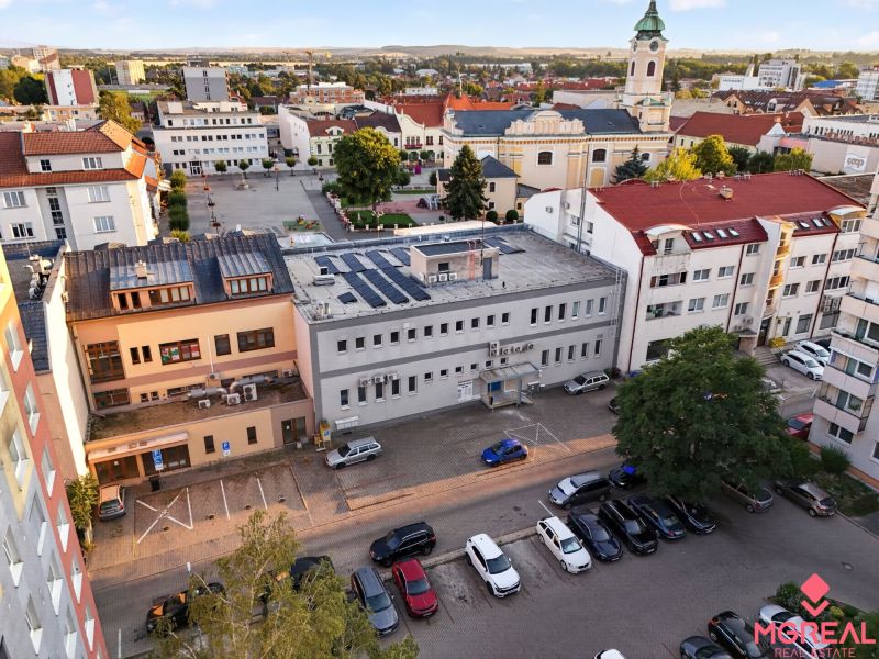 Blick auf M.R. Štefánik in Topoľčany mit Geschäftsräumen und einer Kirche im Hintergrund.