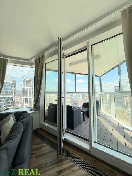 Wohnzimmer mit Sofa und Zugang zum Balkon in einer 3-Zimmer-Wohnung mit Aussicht.