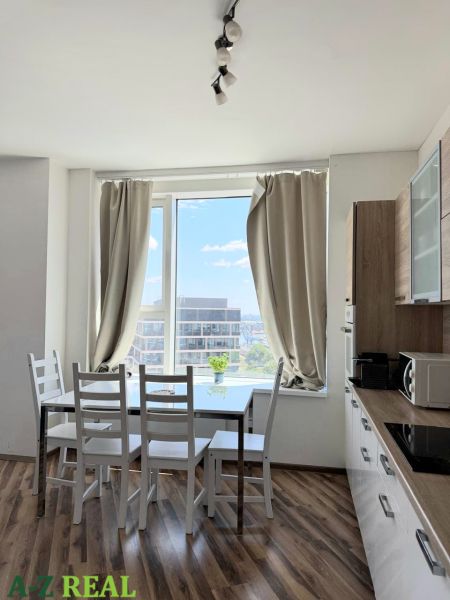 Küche mit Esstisch, Boden mit Holzdekor, in einer 3-Zimmer-Wohnung.