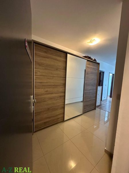 Flur mit Einbauschrank mit Schiebetüren und Boden in Holzoptik.