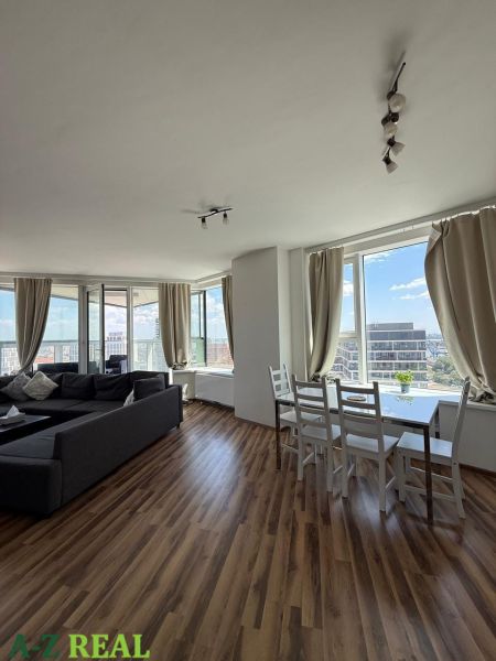 Wohnzimmer in einer 3-Zimmer-Wohnung mit Holzboden und großen Fenstern.