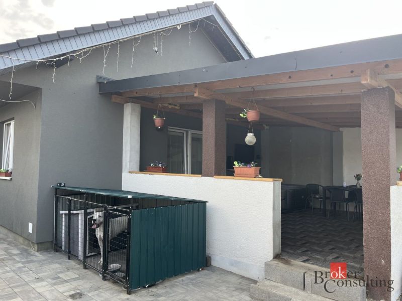 Ein Einfamilienhaus in Čaňa in der SNP-Straße mit Terrasse, Pflastersteinen und einem eingezäunten Auslauf für den Hund.