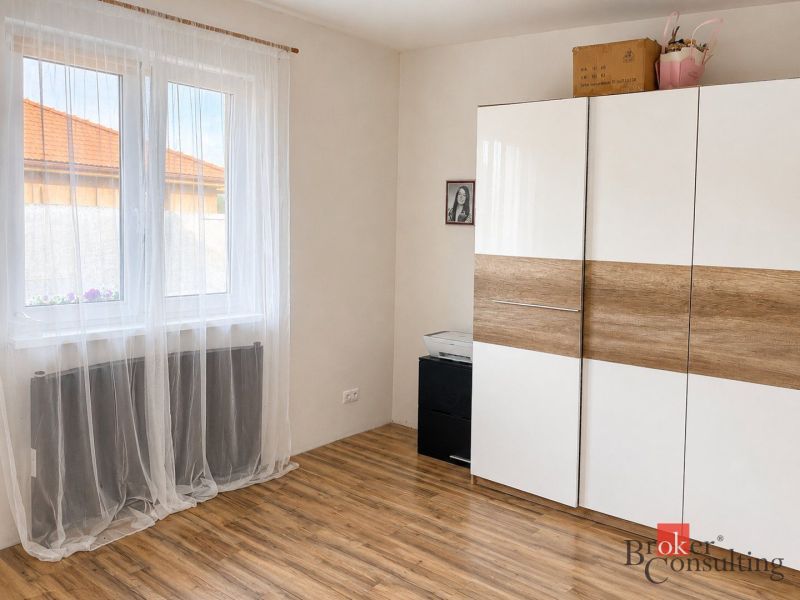Weißer Schrank mit Holzdekor und Vorhängen im Zimmer eines Einfamilienhauses.