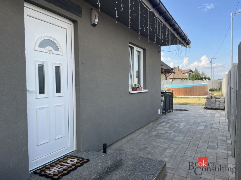 Das Einfamilienhaus in der SNP-Straße in Čaňa hat eine graue Fassade und einen gepflegten Garten mit Pool.