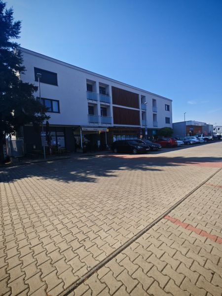 Das Gebäude in der Senická Straße in Rohožník mit Parkplätzen im Vordergrund.
