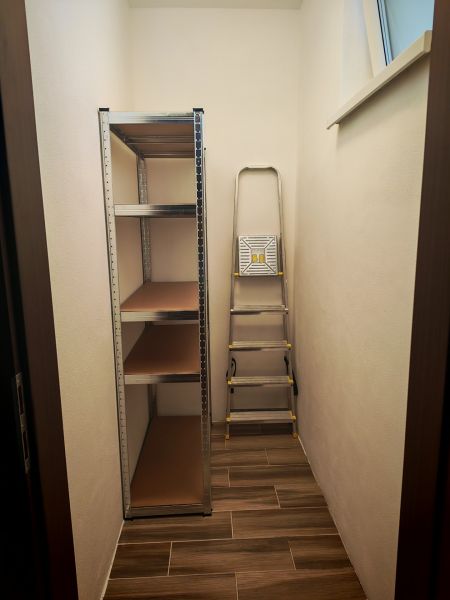 Stauraum in einer 2-Zimmer-Wohnung mit Regalsystem und Leiter.
