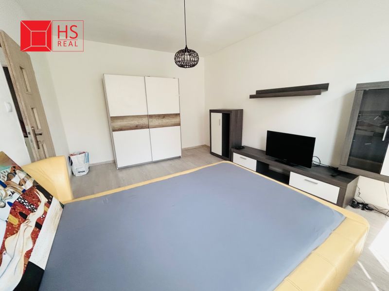 Ein Zimmer mit Fernseher und Schrank, 1-Zimmer-Wohnung, Boden mit Holzdekor.