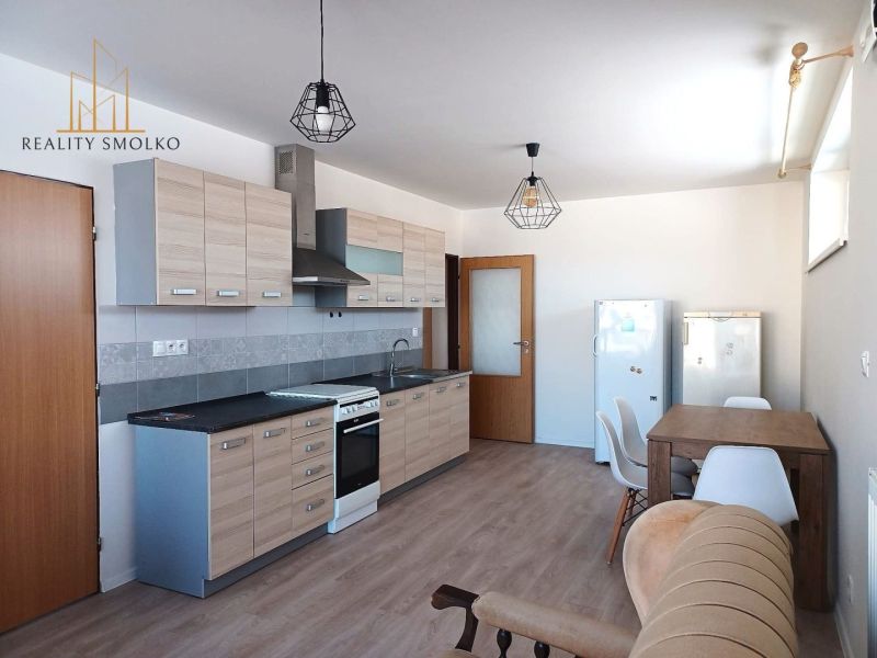 Küche in einer 2-Zimmer-Wohnung mit Holzboden und Esstisch.