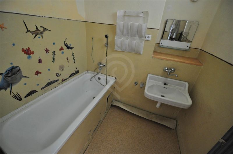 Badezimmer in einer 2-Zimmer-Wohnung mit Badewanne und maritimer Wanddekoration.