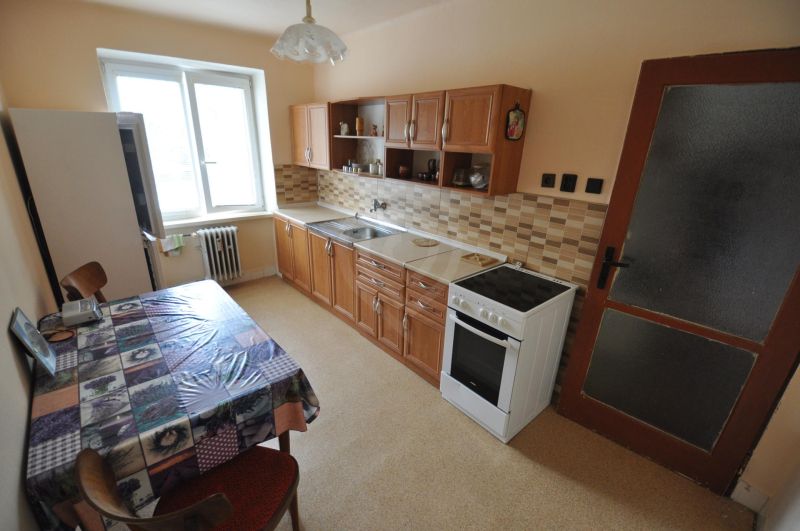 Küche in einer 2-Zimmer-Wohnung mit Esstisch, Küchenzeile und Geräten.