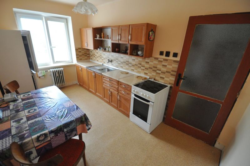 Küche einer 2-Zimmer-Wohnung mit Esstisch, Küchenzeile und Elektroherd.