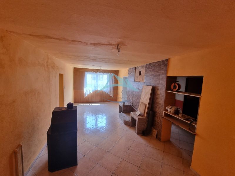 Wohnzimmer in einem Einfamilienhaus mit Fliesenboden und einem Lichtfenster.