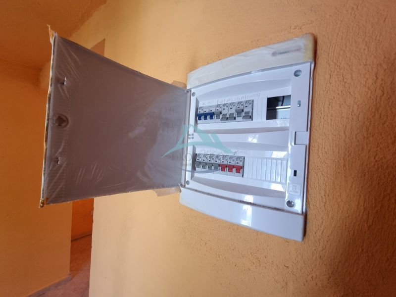 Ein elektrischer Verteilerkasten mit offenen Türen im Inneren eines Einfamilienhauses.