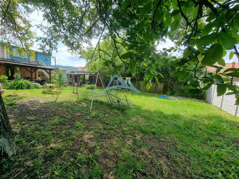 Der Garten beim Einfamilienhaus in der Šípošova-Straße in Šahy mit Schaukel und Bäumen.
