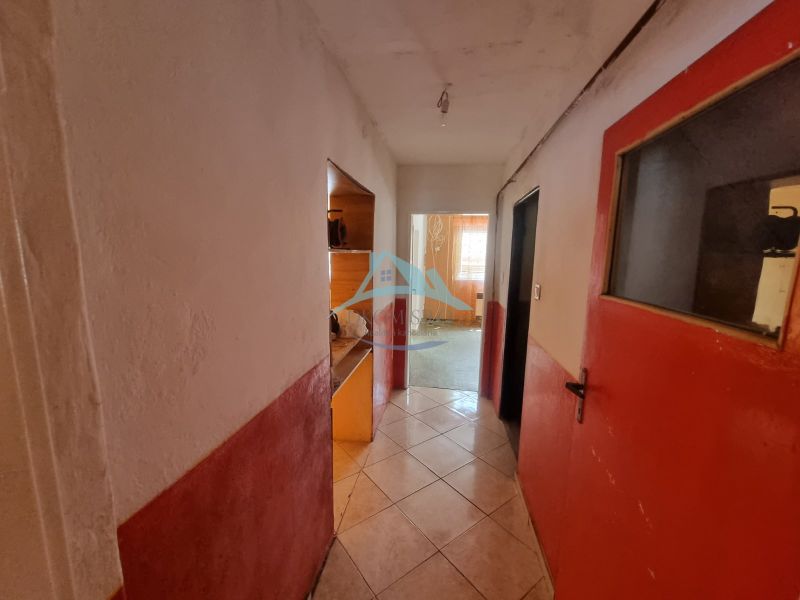 Der Flur in einem Einfamilienhaus mit gefliestem Boden und roten Türen.
