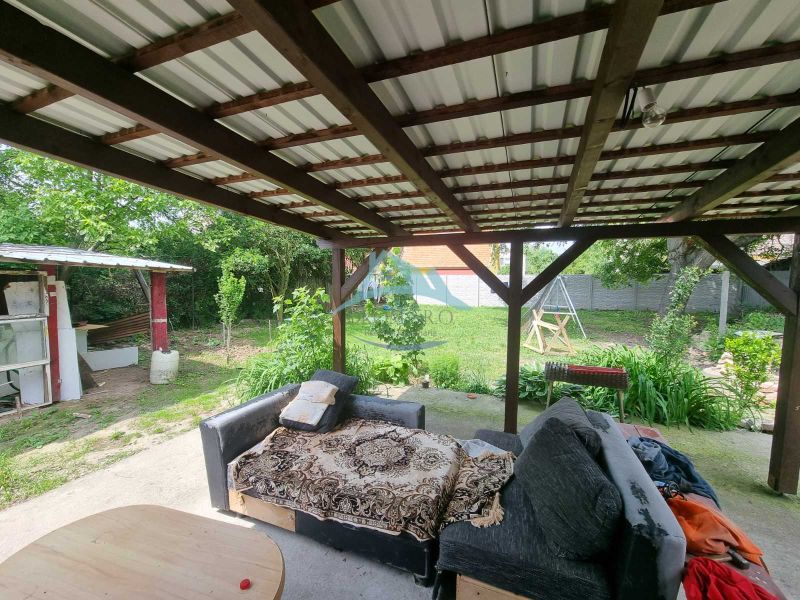 Die Veranda des Einfamilienhauses in der Šípošová-Straße in Šahy mit einem Sofa und einem Garten.