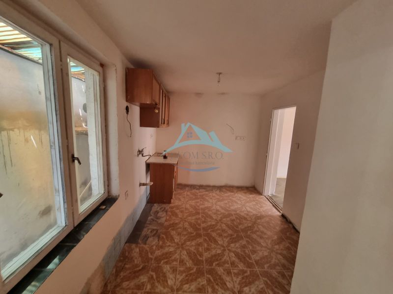 Küche im Einfamilienhaus mit Fenster und Boden in Holzoptik.