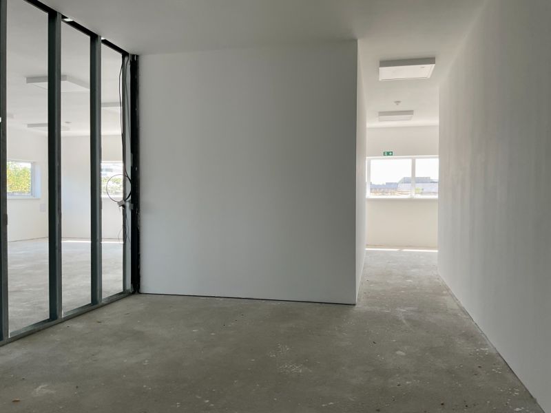 Innenräume von Lagern und Hallen mit transparenten Glaswänden und Betonboden.