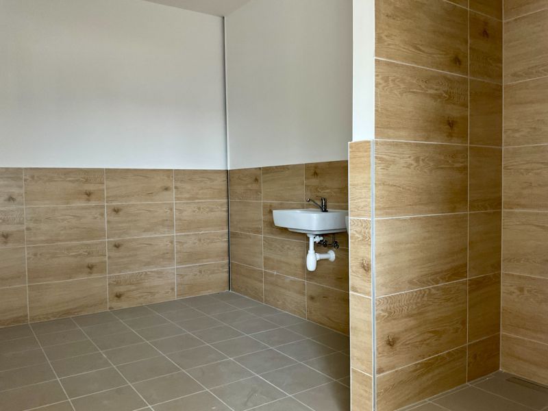 Ein Raum mit Wänden in Holzdekor und einem Waschbecken in Lagern und Hallen.