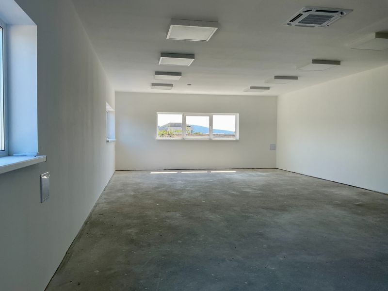 Geräumiger leerer Innenraum in Lagerhäusern und Hallen mit großen Fenstern.